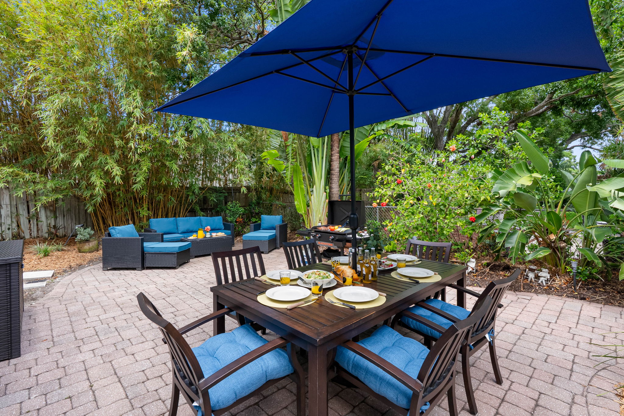 This private patio is your personal retreat—featuring comfortable lounge seating, a shaded dining area for six, and a backdrop of palms and hibiscus that transports you straight to paradise.
