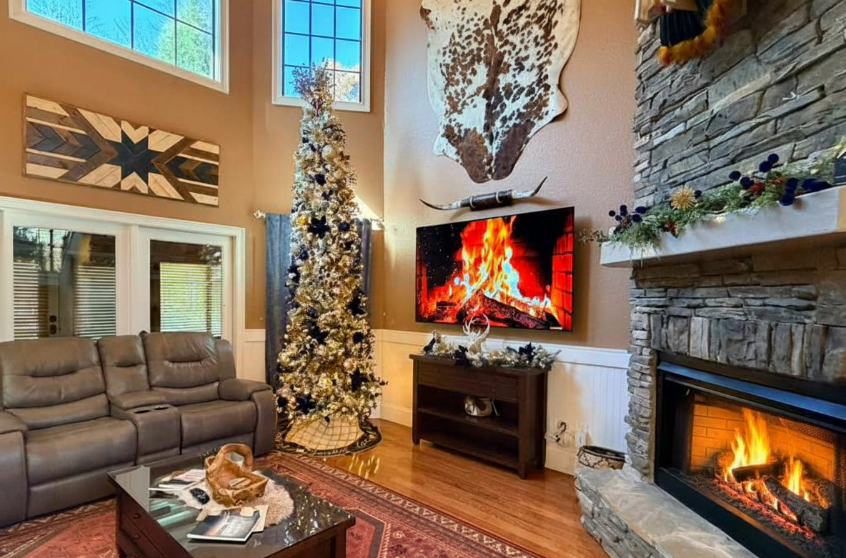 Fireside luxury awaits! Enjoy the ultimate cozy mountain ambiance with our majestic stone fireplace and large windows framing the winter scenery.