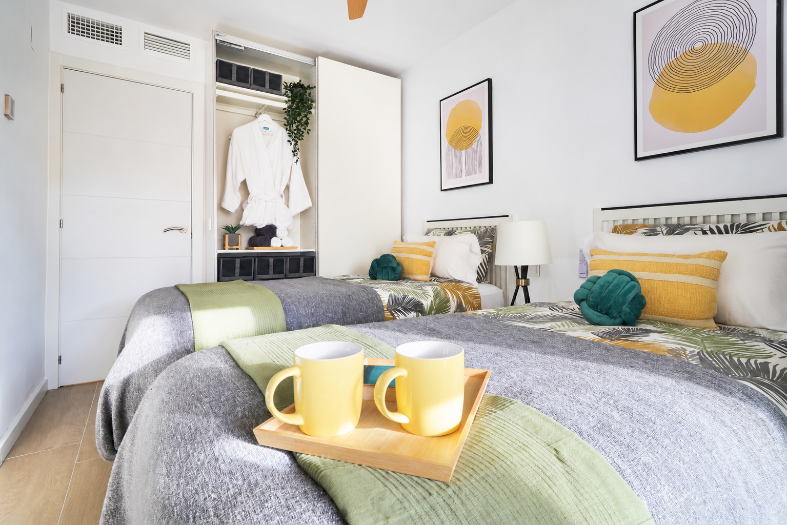 Bright and calming twin bedroom with tropical tones, soft linens, and direct access to the terrace - perfect for relaxed mornings and restful nights.