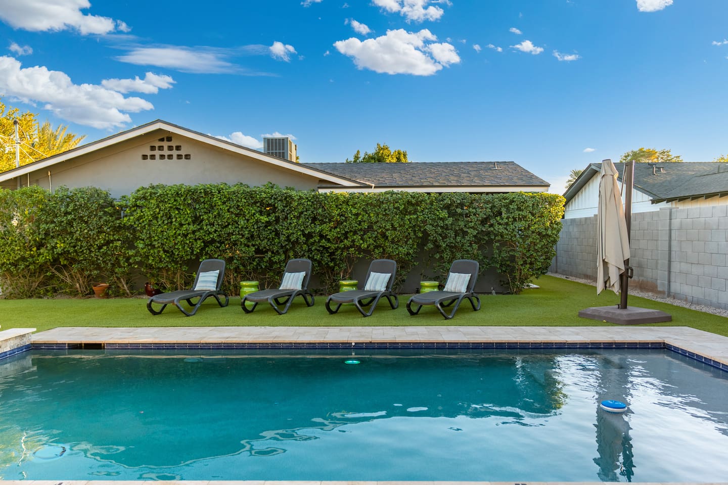 Comfortable poolside chairs, perfect for lounging and soaking up the sun in a relaxed outdoor setting.