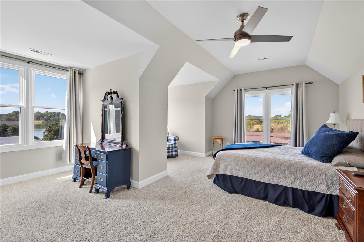 Relaxing bedroom retreat with water views and private lounge area.