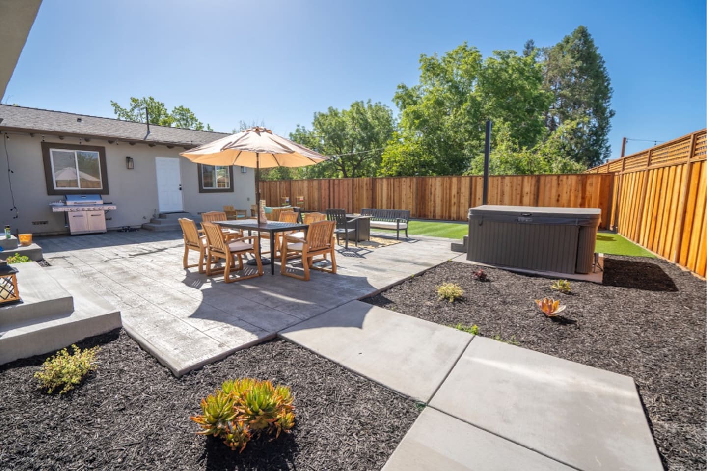 Backyard with hot tub, outdoor dining and seating with fire pit.