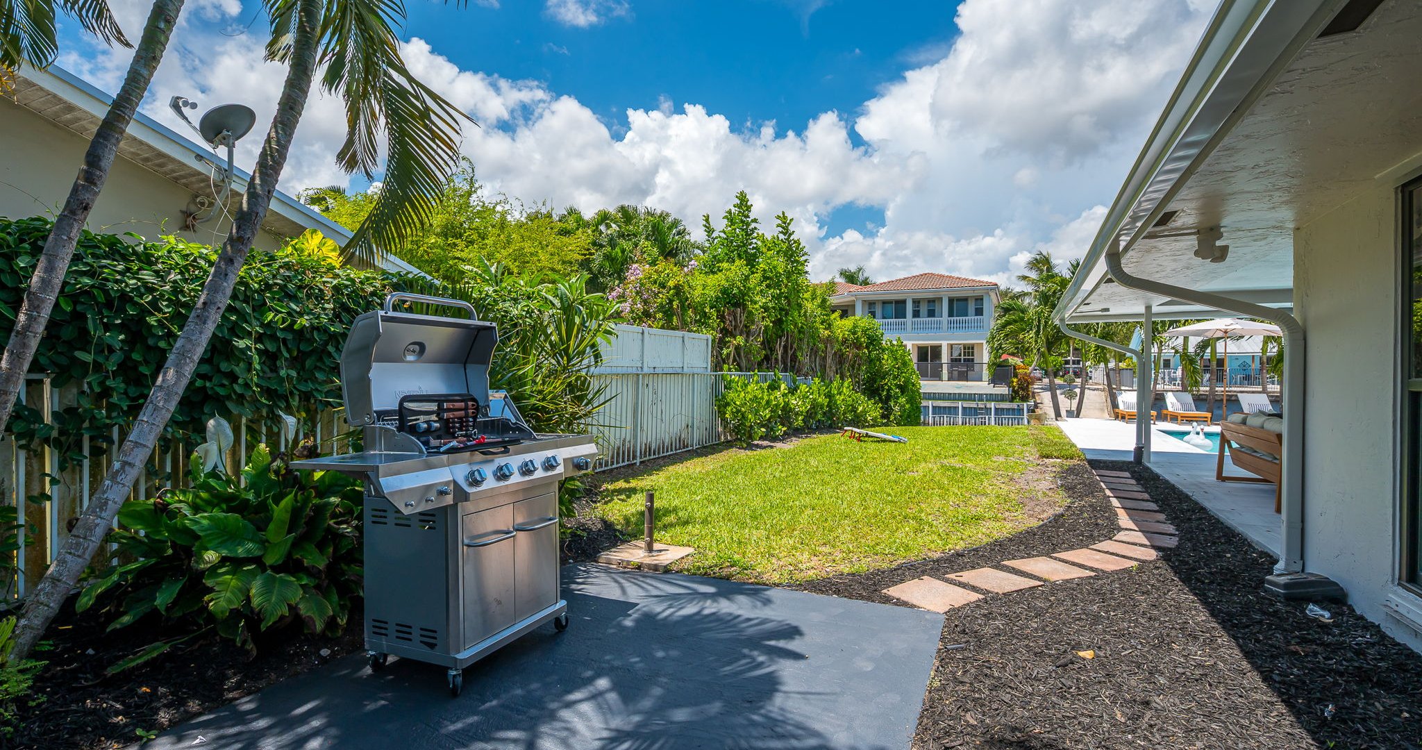 Step outside to your private backyard oasis, complete with a stainless steel barbecue grill and lush tropical landscaping. Whether you’re grilling up a family feast, lounging poolside, or enjoying the canal views, this space is designed for relaxation.