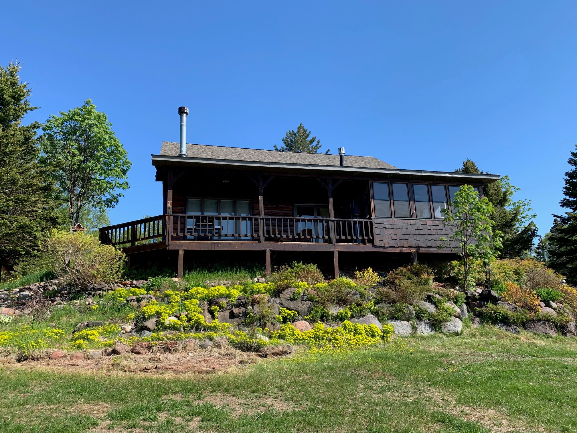 View from backyard i.e. Lake Superior showing enclosed porch, cover and uncovered deck. 