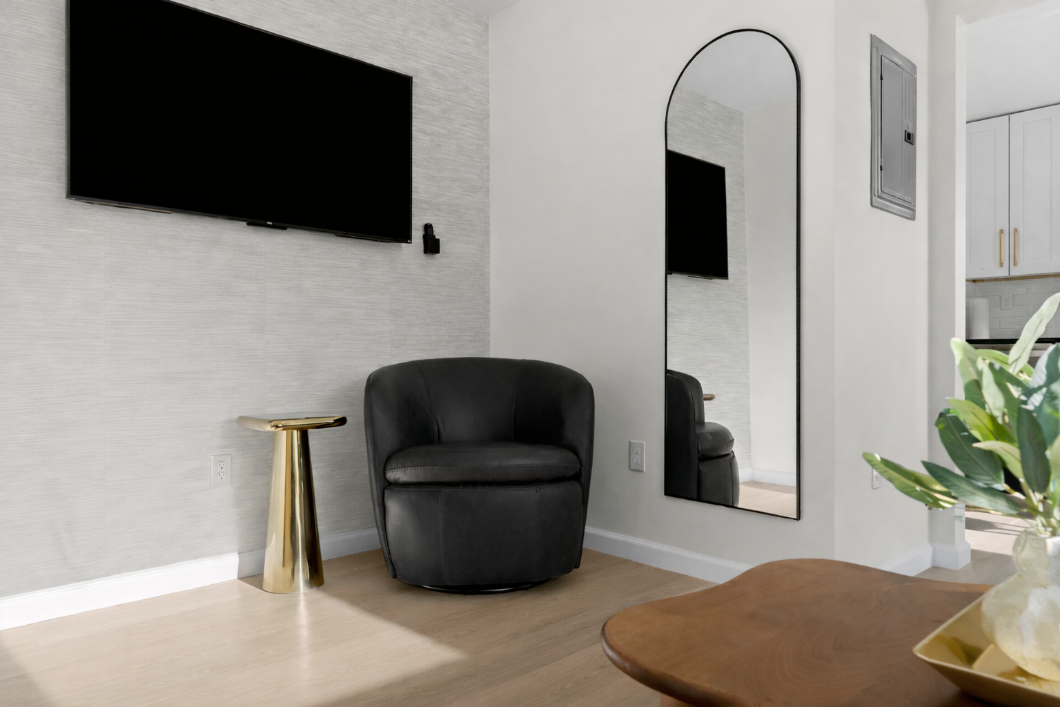 Stylish lounge nook with a smart TV, plush accent chair, and warm natural light—perfect for unwinding with a show or a quiet moment.