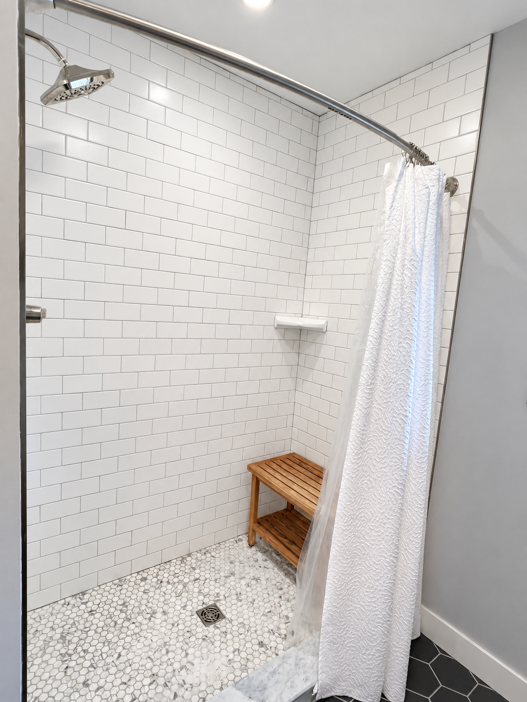 Tiled shower with bench.