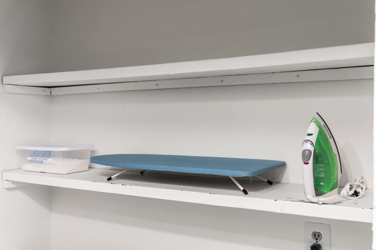 Stay organized with this spacious entryway closet featuring shelves and an ironing board for your convenience.