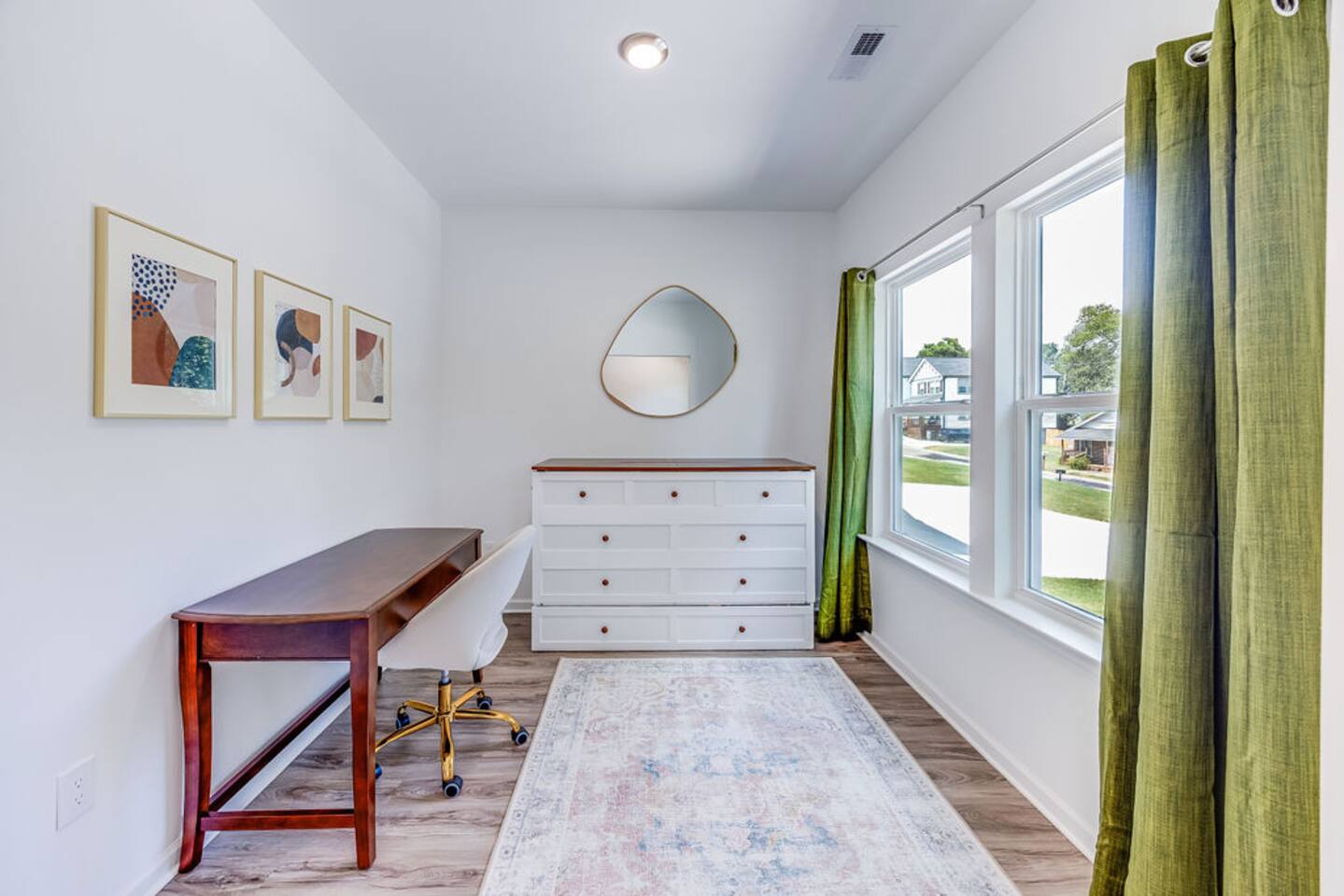 Functional office room with large windows for natural light, featuring a Murphy bed that easily folds out into a comfortable queen bed for extra sleeping space.