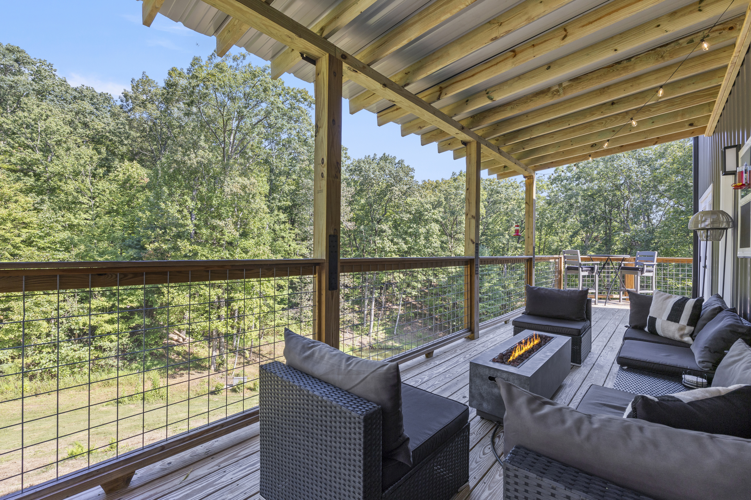 Spacious deck with comfy seating and peaceful wooded views — perfect for morning coffee or evening drinks.