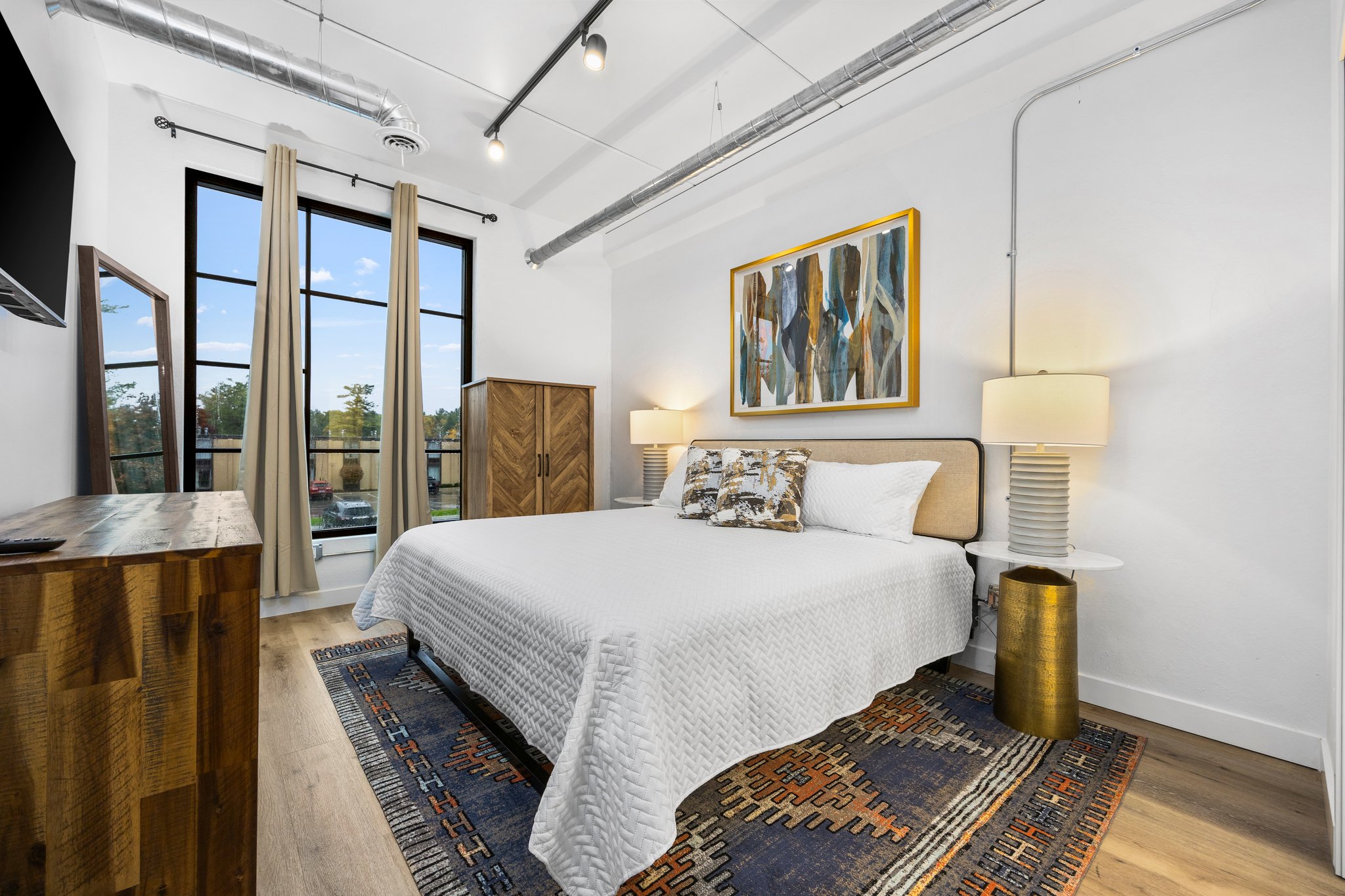 Wake up refreshed in this serene master suite with king size bed, where sunlight streams through tall windows and the morning begins with peaceful views and quiet comfort.