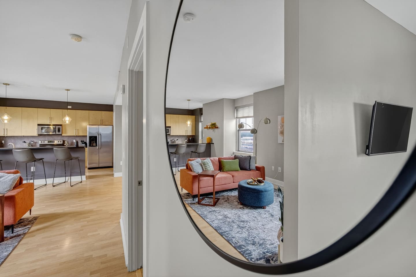 Step into style!  This playful mirror view highlights the seamless flow from bedroom to living area. Modern decor, open layout, and natural light create the perfect space to relax, work, or entertain.