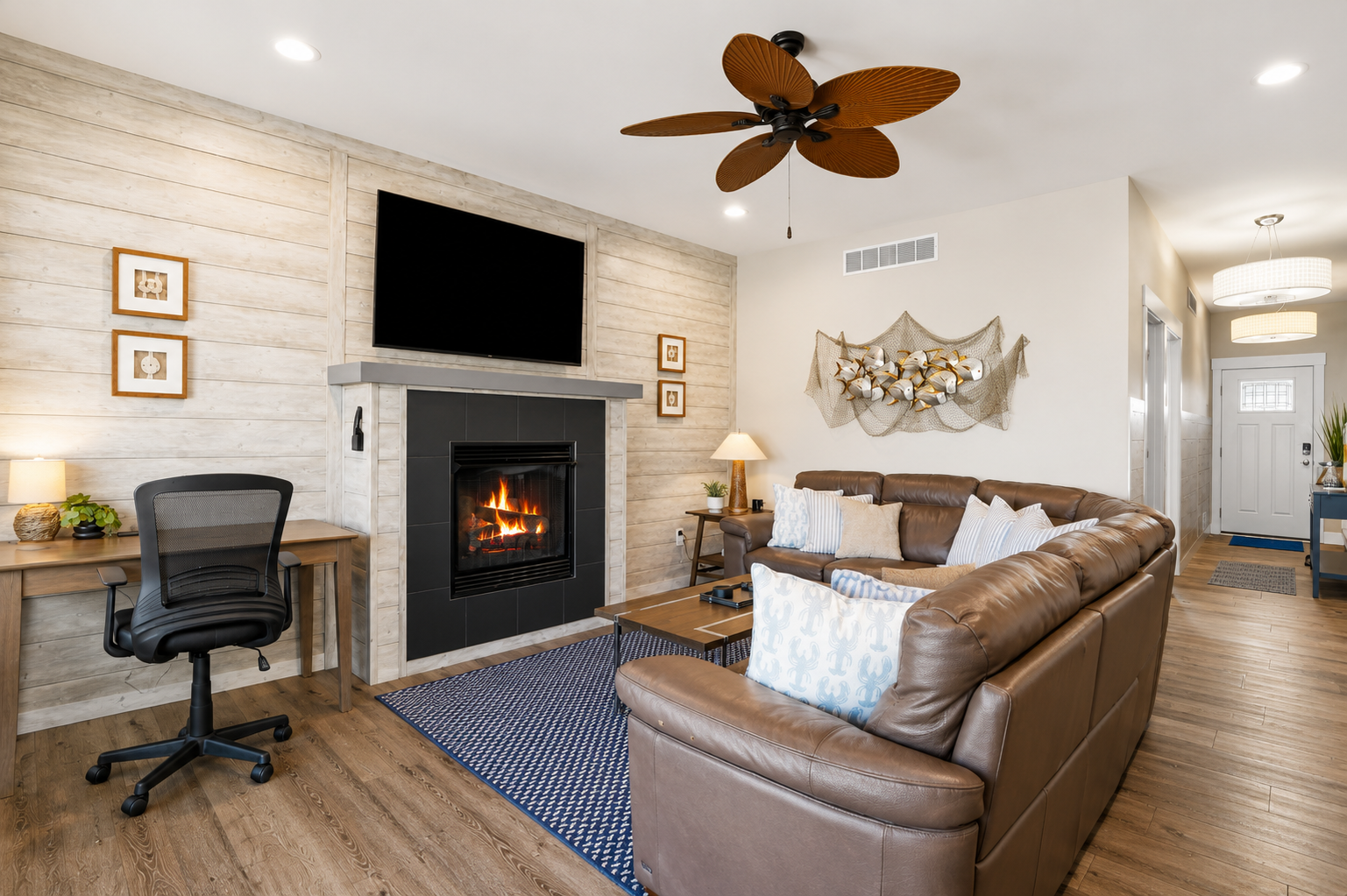 The heart of the home, this inviting living room combines modern coastal style with everyday comfort. Enjoy the cozy fireplace, spacious seating, and a convenient workspace—perfect for relaxing, reconnecting, or working remotely.