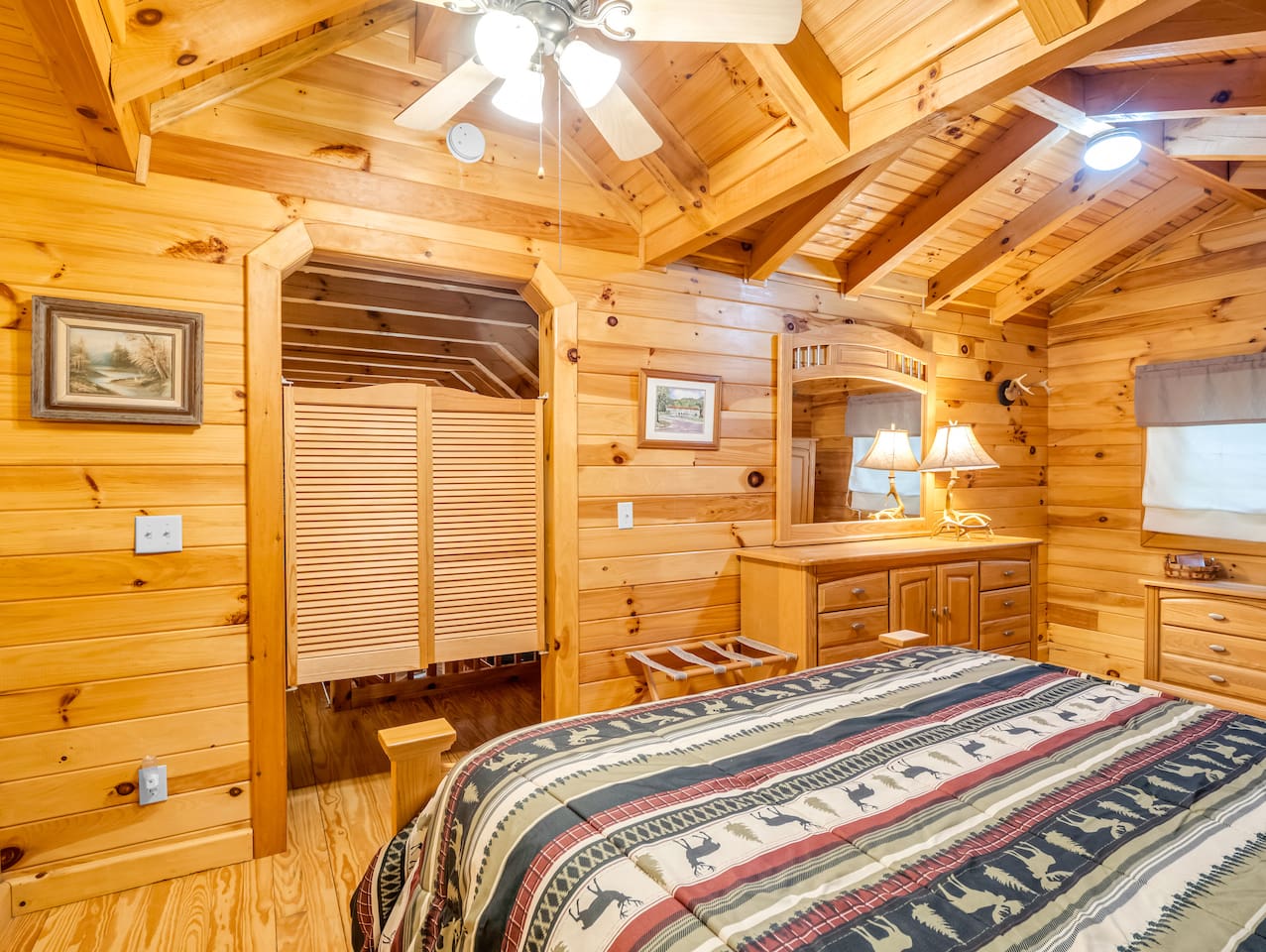 Third level bedroom featuring double bed, saloon doors, and plenty of storage space