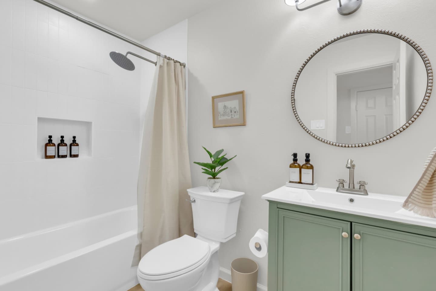 Stylish full bathroom with a bath, rainfall shower, and Ginger Lily Farms shampoo, conditioner, and shower gel. Fresh essentials provided for every stay.