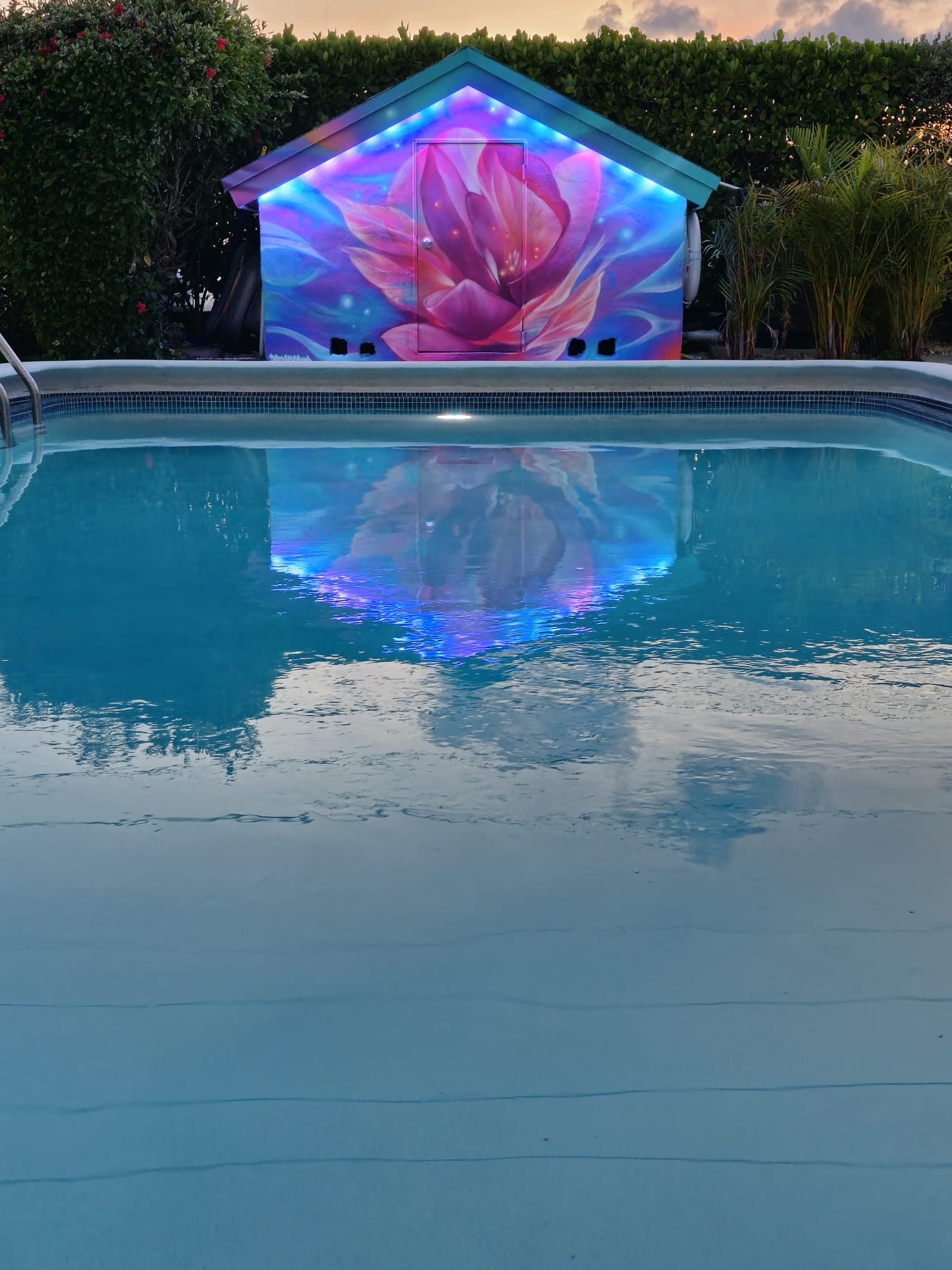 Featuring pool house mural with LED lights at night.