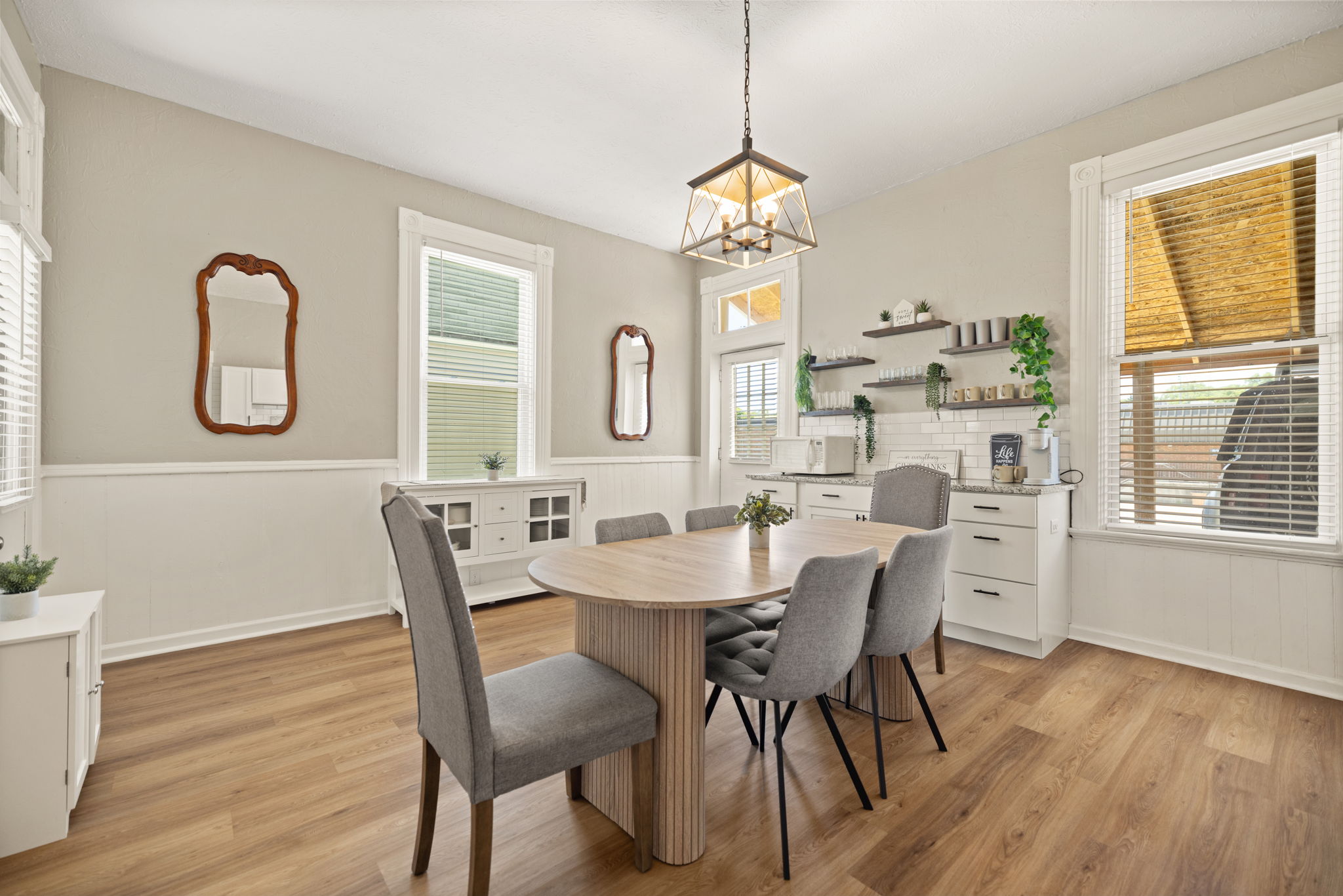 Charming dining area with pendant chandelier, wood table, and upholstered chairs. Perfect for meals together!