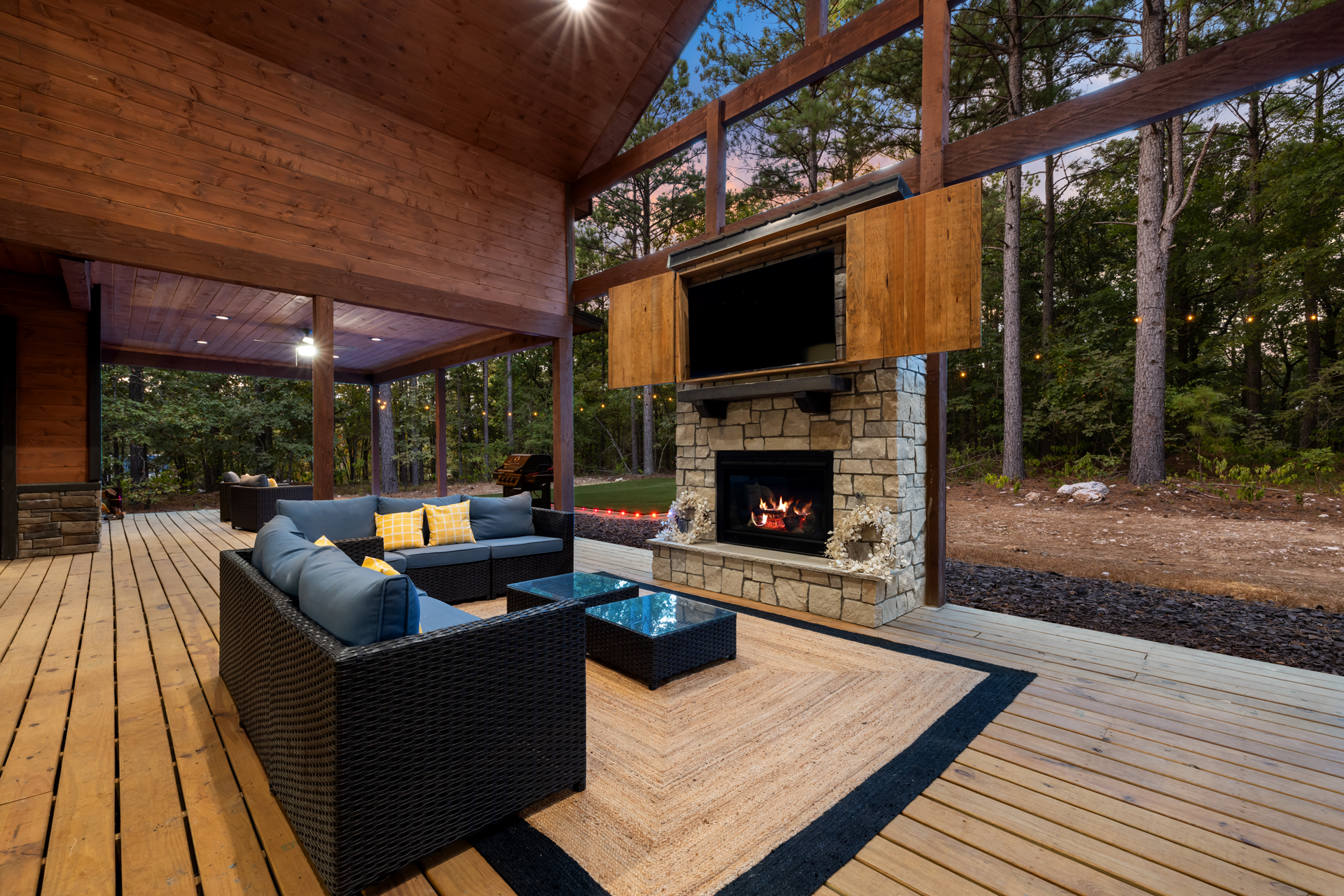 Spacious outdoor patio featuring comfortable seating, a cozy fireplace, and TV—perfect for relaxing, dining, and entertainment outdoors.