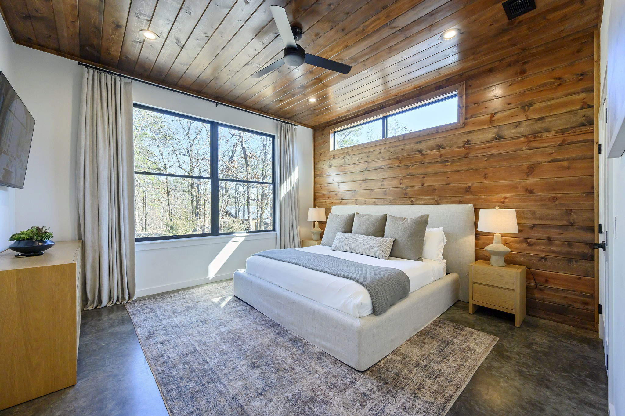 King Suite 3 - Large and spacious suite with cedar wood paneling, designer finishes, smart TV, premium king mattress, and luxury bedding. Includes stunning views of the hardwood forest. 