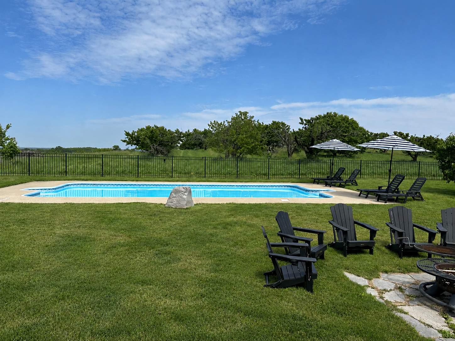 Your private pool oasis awaits! Lounge under striped umbrellas, cool off in the sparkling pool, gather around the fire pit, and soak in peaceful orchard views. The perfect backdrop for family vacations, friend getaways, and summer memories.