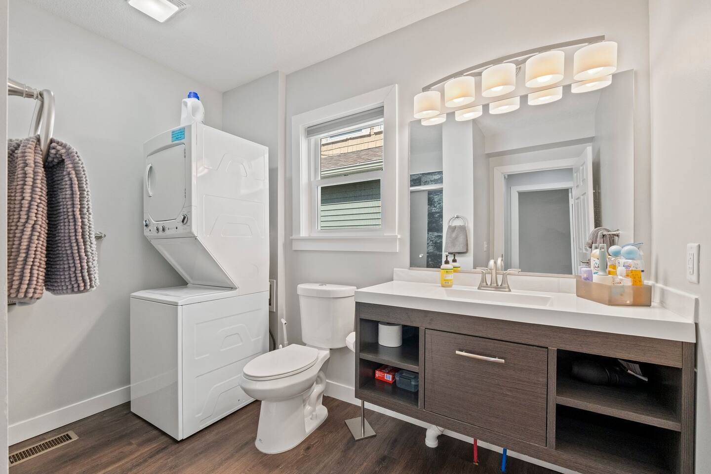 Modern full bathroom with the added convenience of an in-unit washer and dryer for a seamless stay.