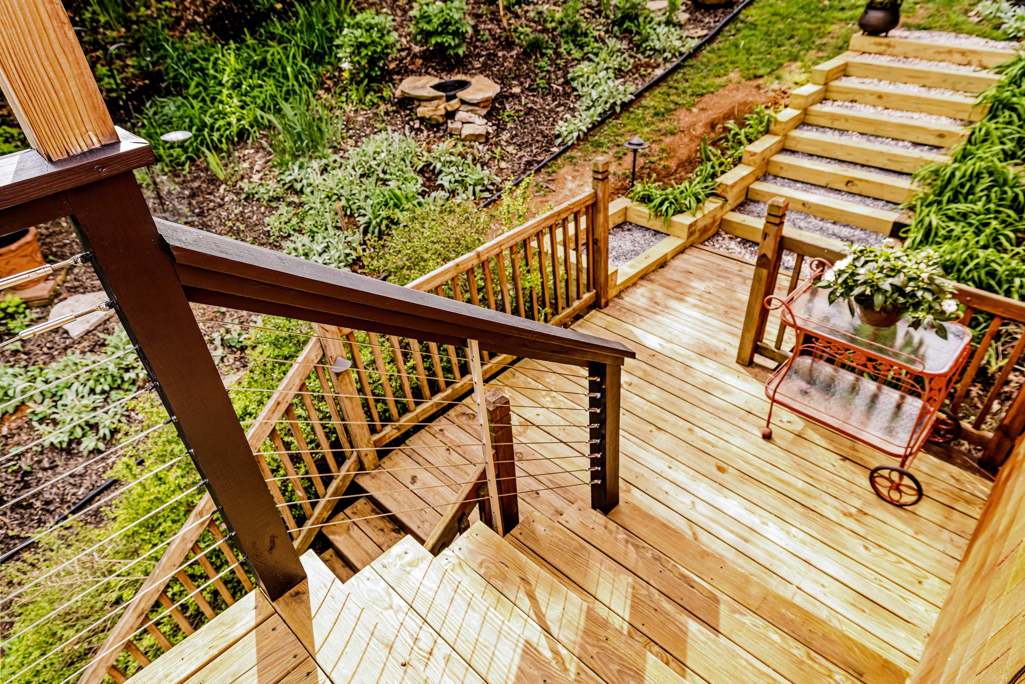 From the main floor deck descend down to the left to reach the lower deck. Or wander up the hill to see the blend of naturalized plants and perennials.