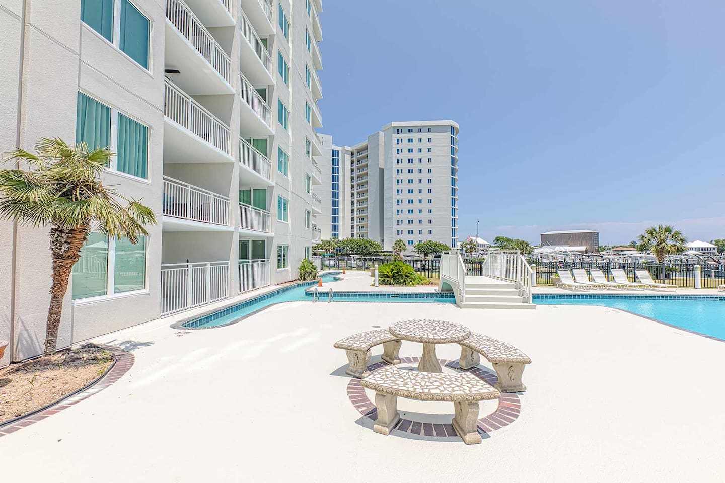 Outdoor Oasis: Dive into relaxation by the pool with palm trees and sunny vibes!