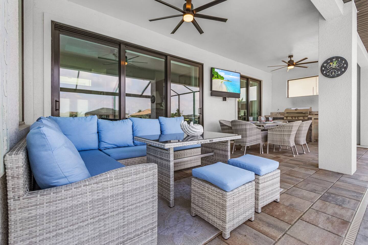 Spacious outdoor area featuring comfortable seating, a BBQ grill, outdoor dining, and an outdoor TV for ultimate entertainment!