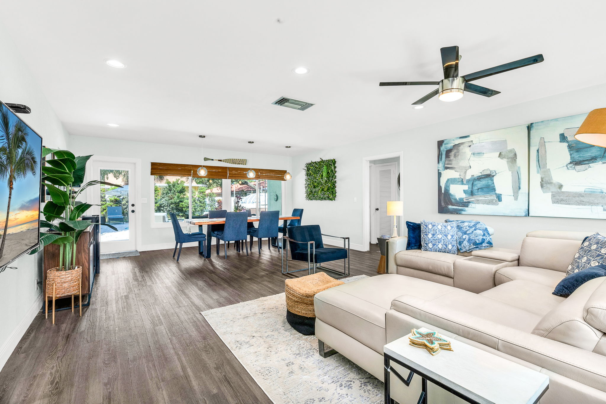 Bright, open-concept living area with modern, plush furnishings, seamlessly blending indoor comfort with outdoor living, and a relaxed coastal vibe - ideal for gathering with family and friends.  