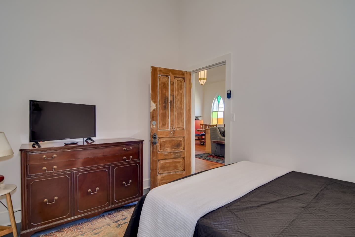 Guest bedroom with cozy queen bed and vintage wood furniture.