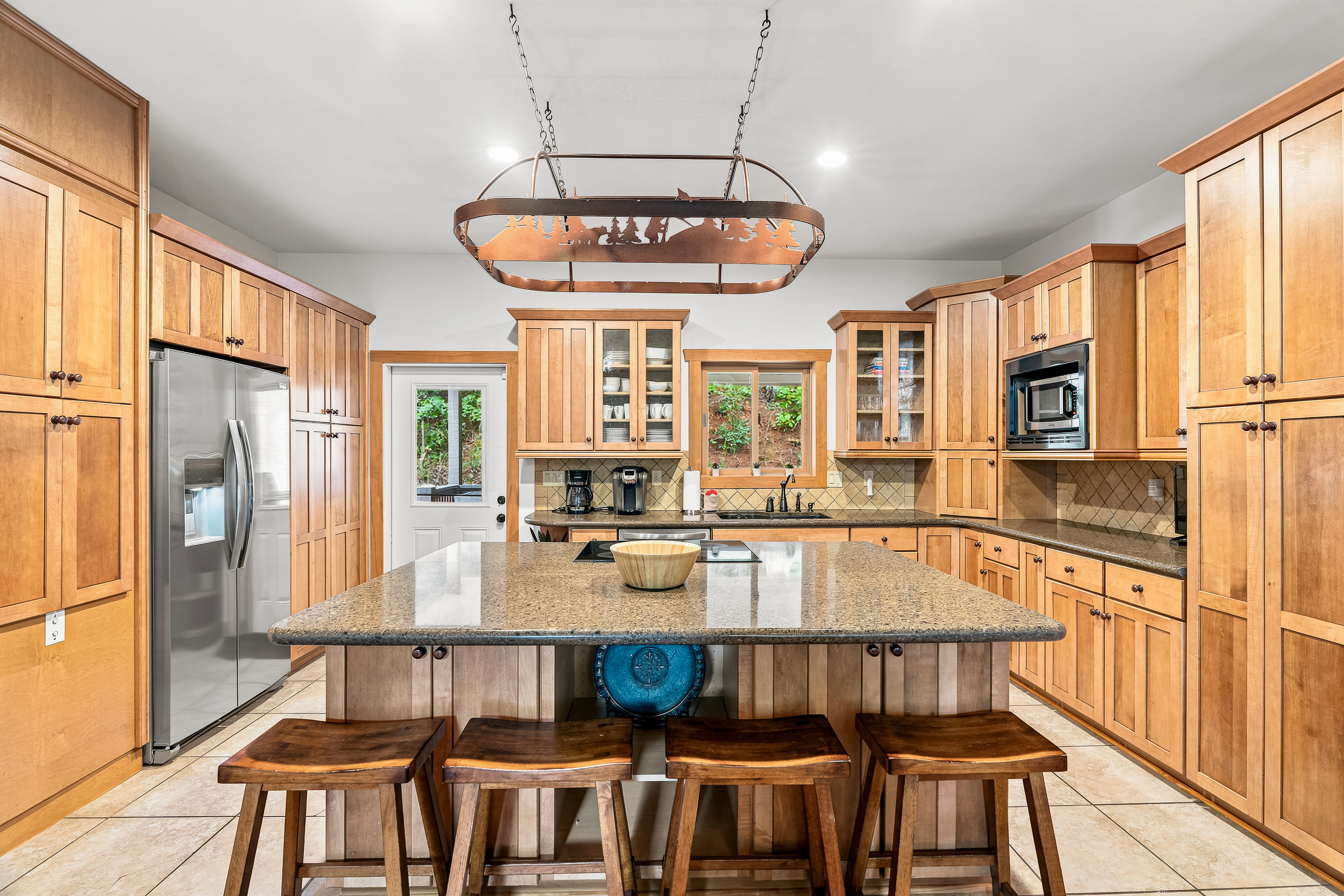 The center island has a beautiful granite counter and a breakfast bar with seating for 4