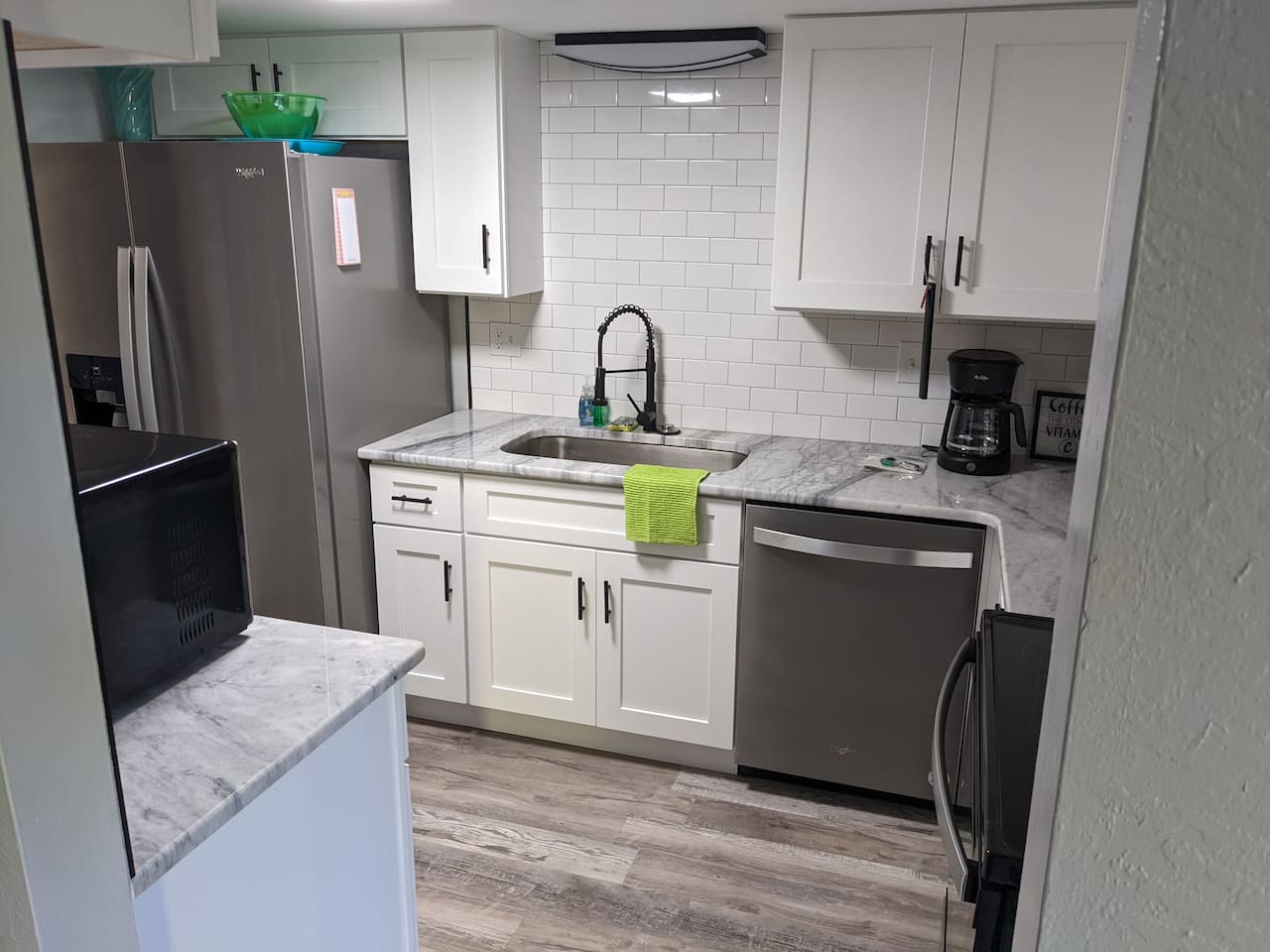 Granite countertops, stainless steel appliances, large sink, many kitchen gadgets, pots, pans, and utensils.