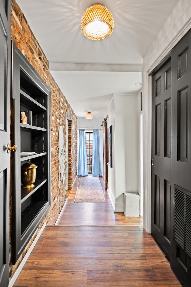 Hallway from kitchen to guest bedrooms and bath. Original exposed brick. 