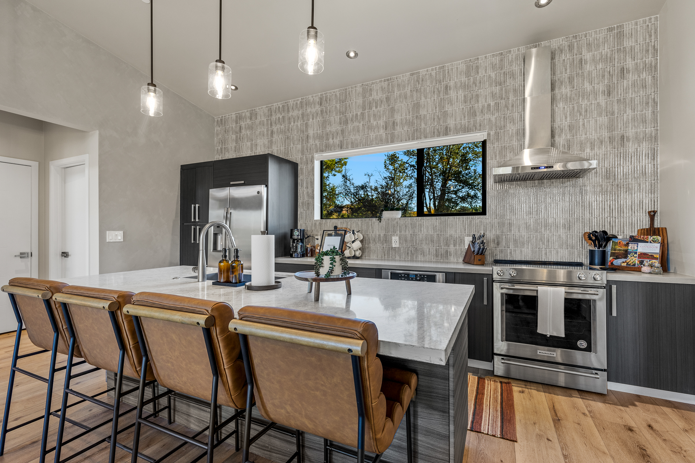 A modern, fully equipped kitchen with a large island and bar seating for 4 - ideal for cooking, gathering, and easy meals at home.