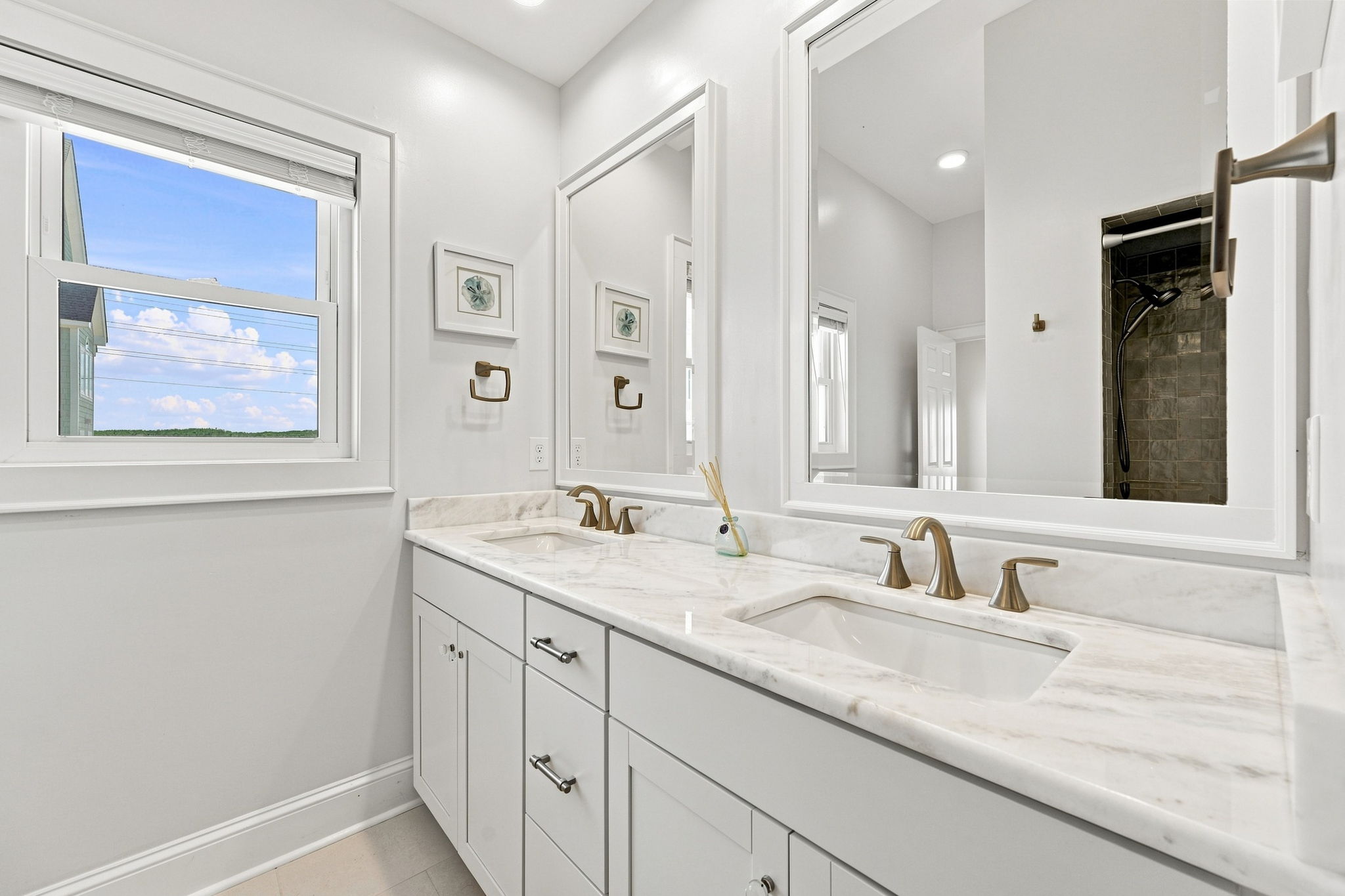 Thoughtfully designed with contemporary fixtures, double sinks, and a clean coastal aesthetic.