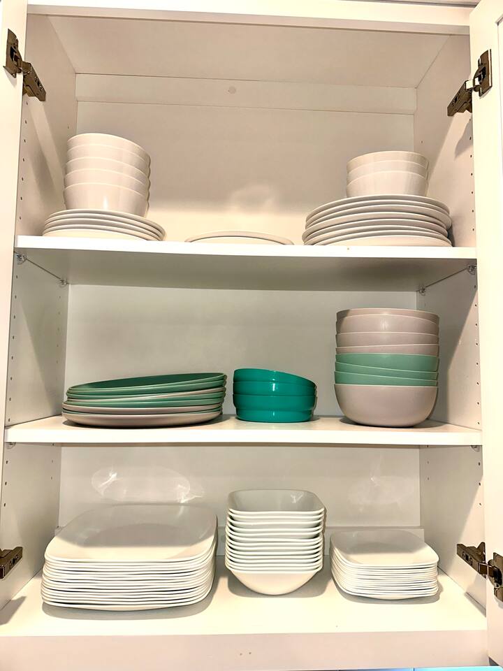Correlle chip-free dishes.  With a variety of plastic plates and bowls.    Extra dishes on top shelf 