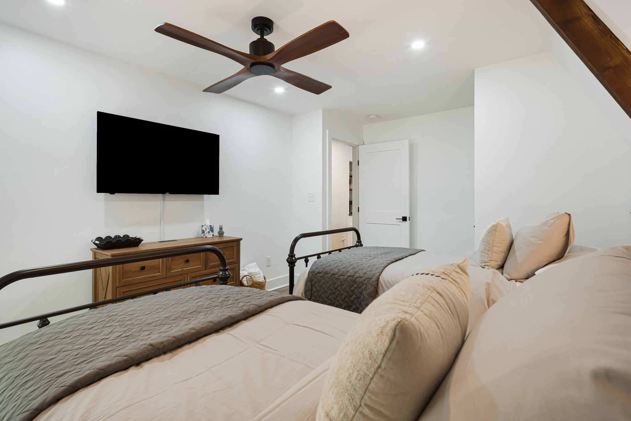 This bedroom on the main floor offers 2 twin beds and its outfitted with a dresser and a walk-in closet with hangers and open shelving for storage. A smart TV, luggage racks and additional blankets are also available for extra convenience.