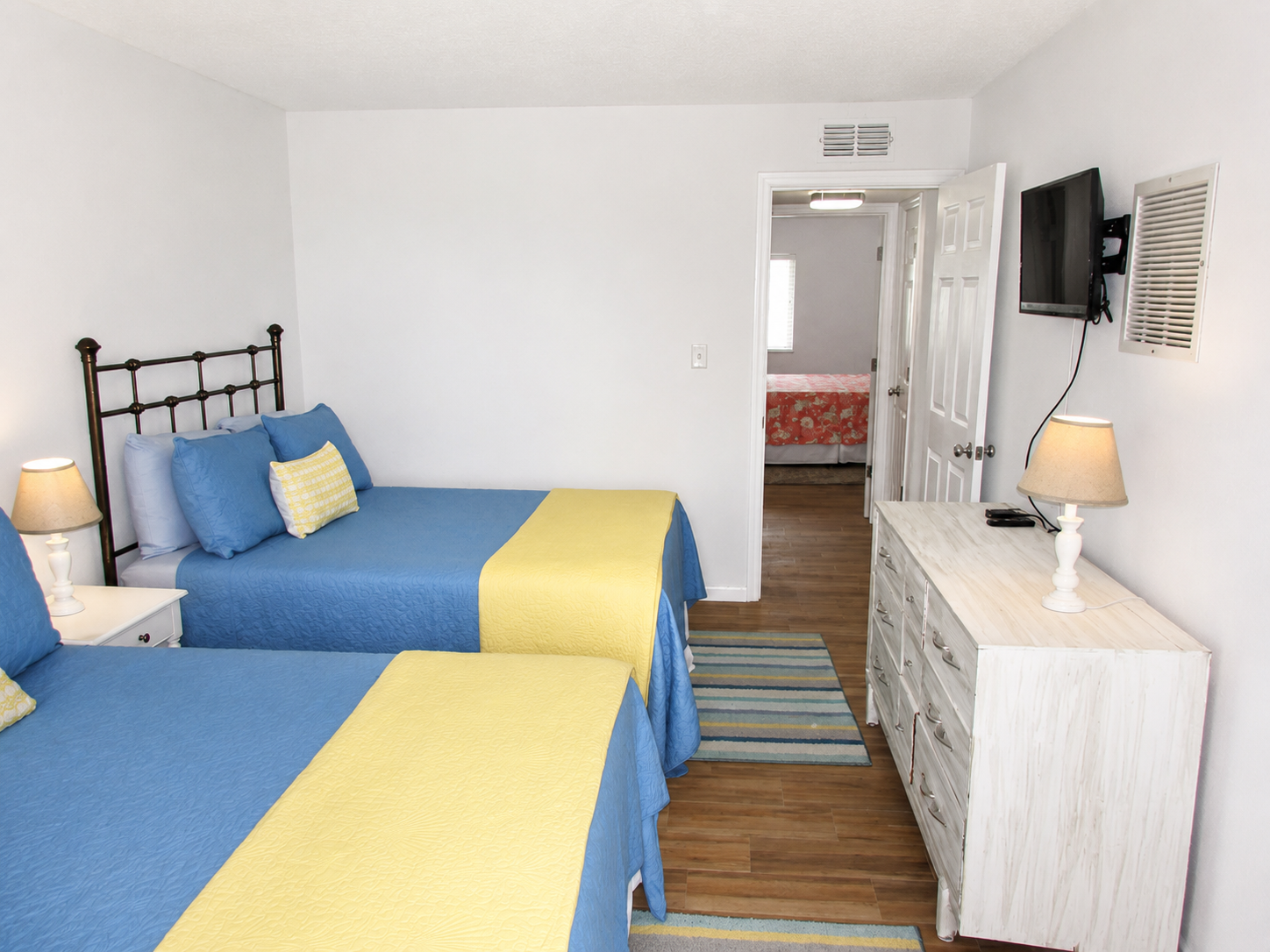 Cheerful twin bedroom with blue and yellow accents, cozy decor, and bright inviting style.