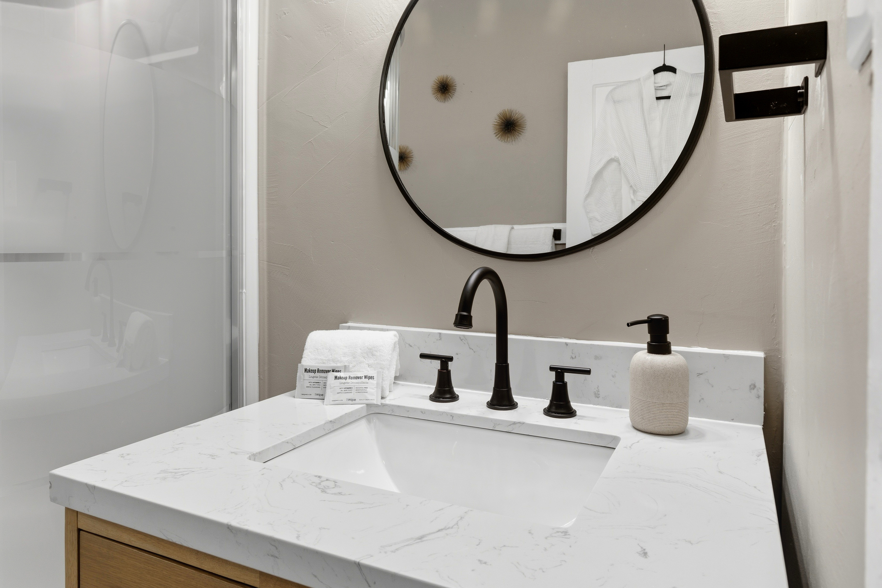 Composite marble-top vanity with matte black fixtures. Soaps, Linens and make-up wipes provided.