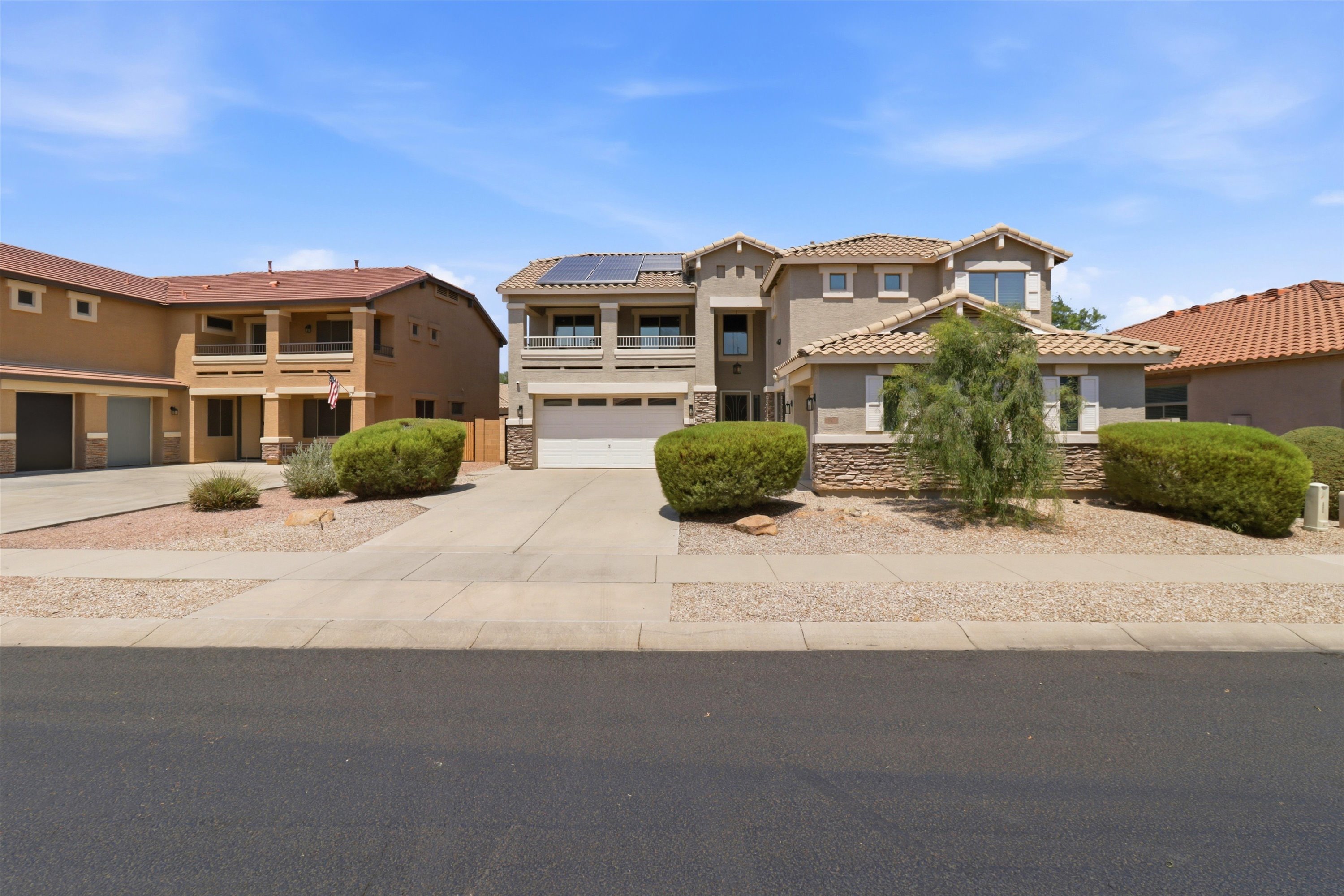 Front exterior with driveway parking, garage access, and a low-maintenance desert yard.
