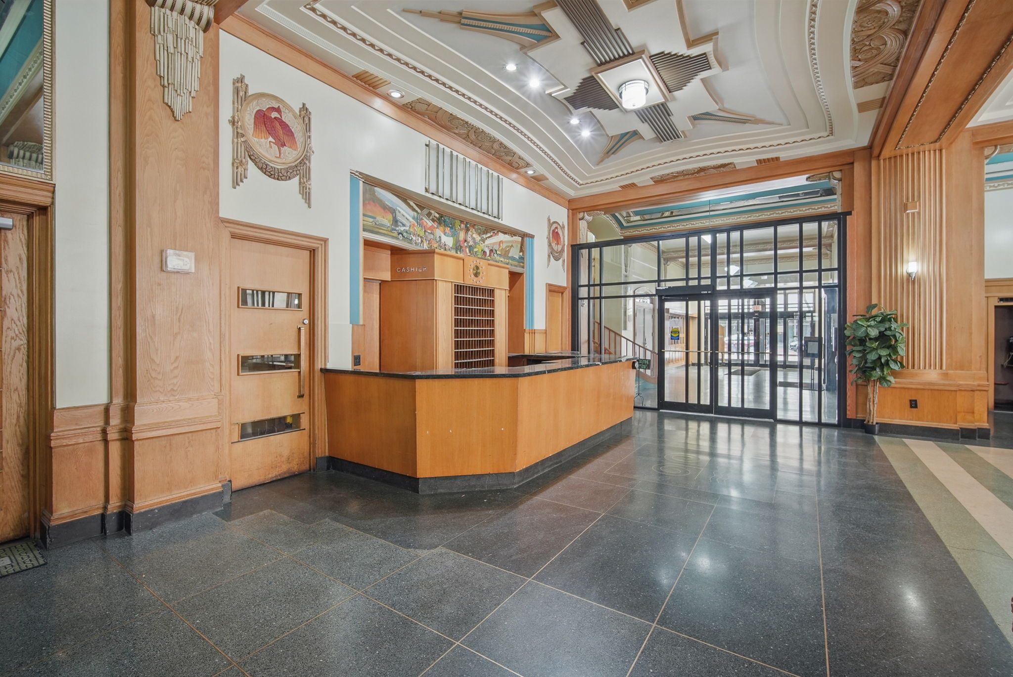 A nod to the past—this original check-in counter sits under hand-painted murals and detailed ceiling art.