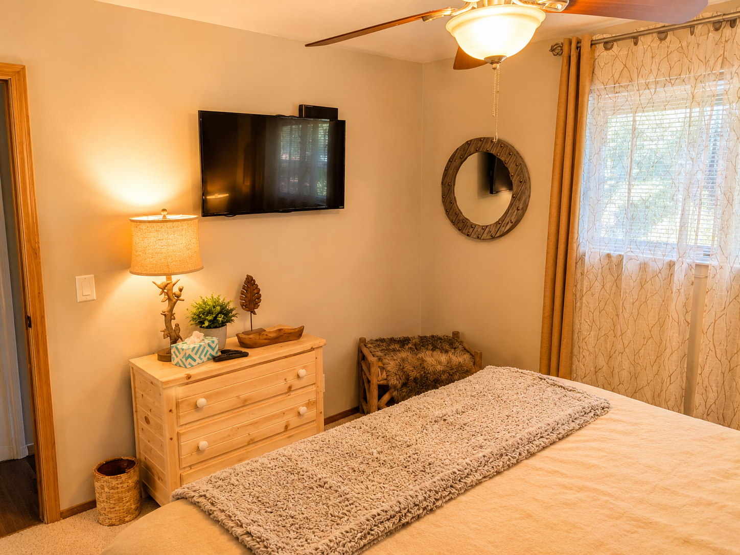 The second downstairs bedroom has a small dresser, luggage rack/bench and closet for storage.