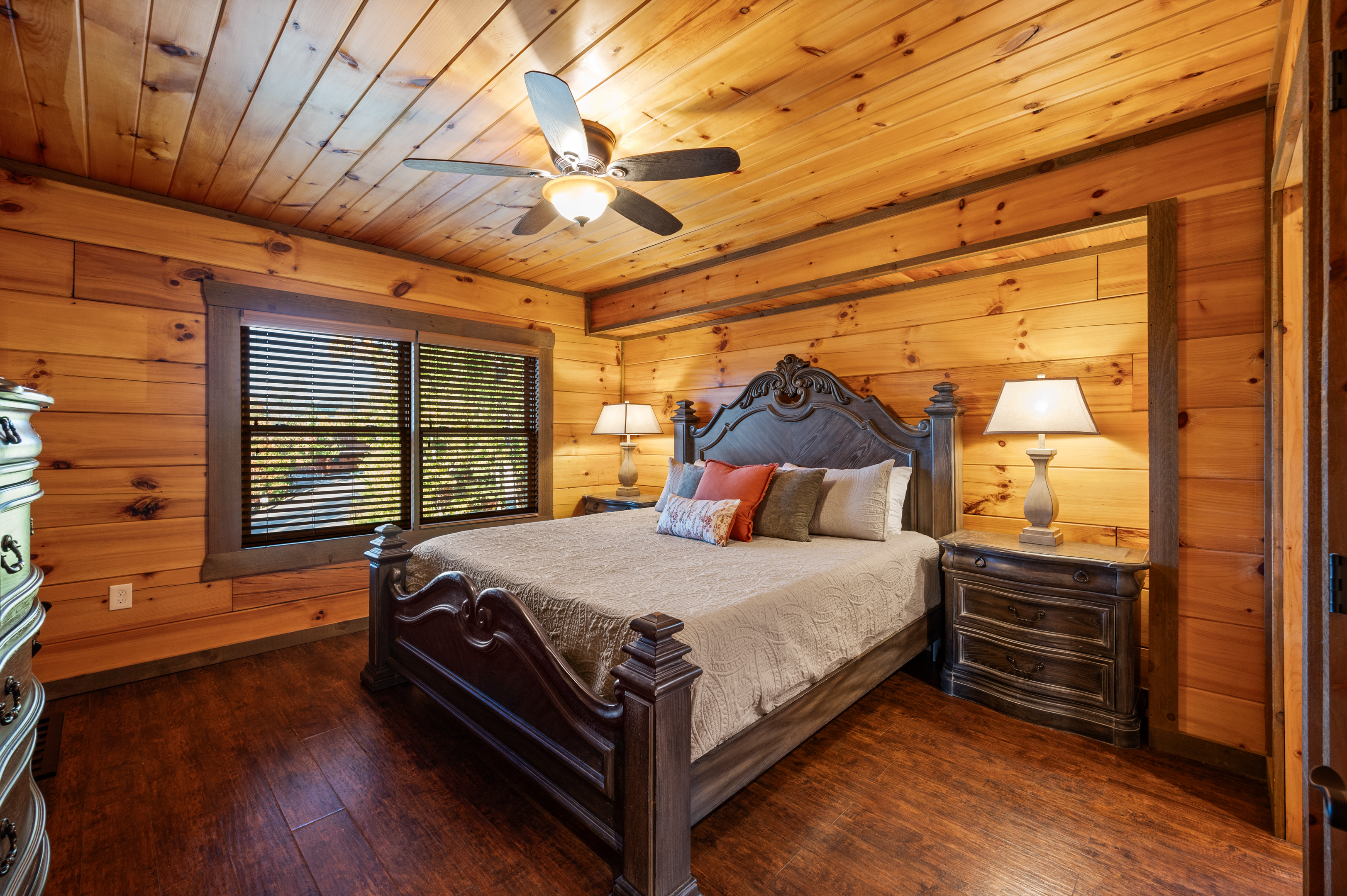The first floor master suite has a king bed, TV, dresser, side tables, ceiling fan, and an ensuite bathroom.