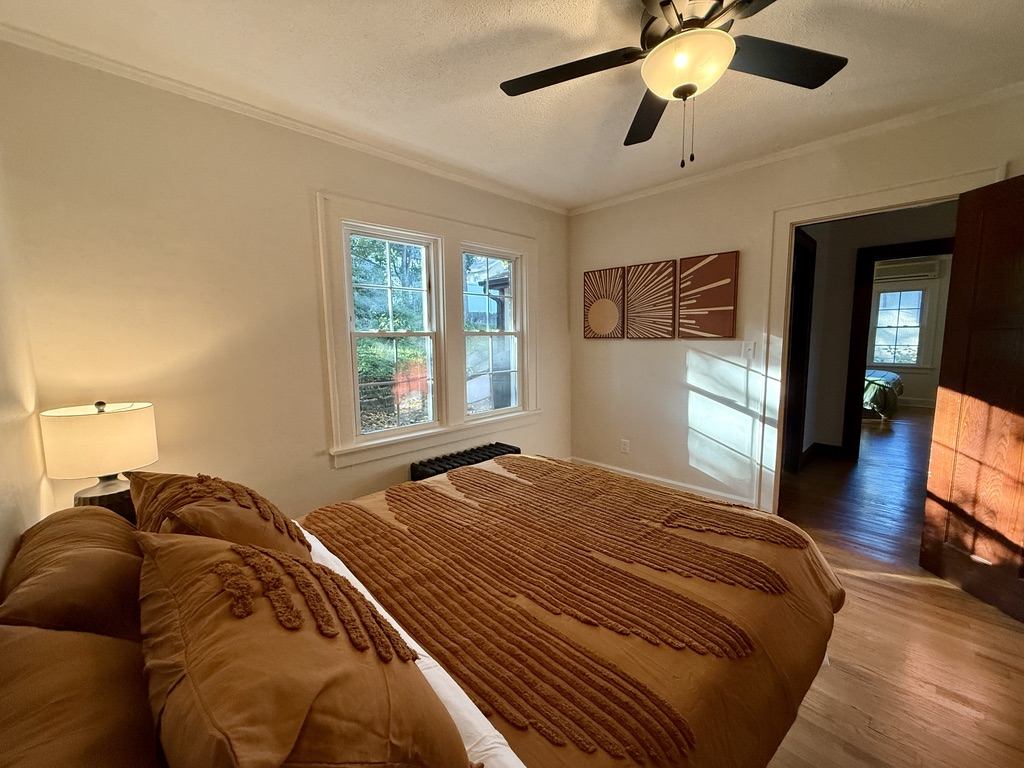 Bedrooms are furnished with a plush Queen bed, large dresser, a closet with hangers, and side tables with charging lamps.