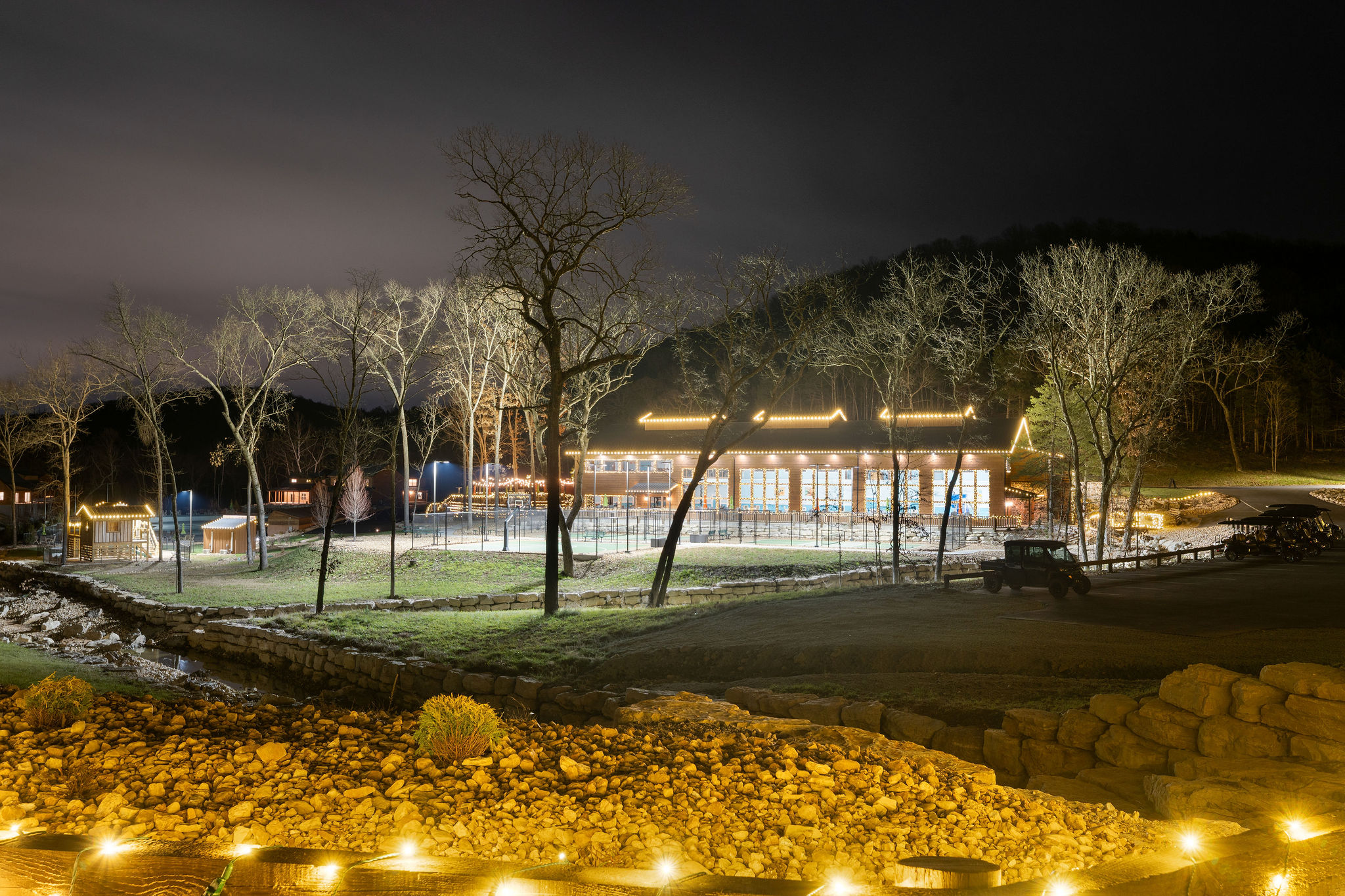 A peaceful nighttime setting with the cabin glowing among the trees.