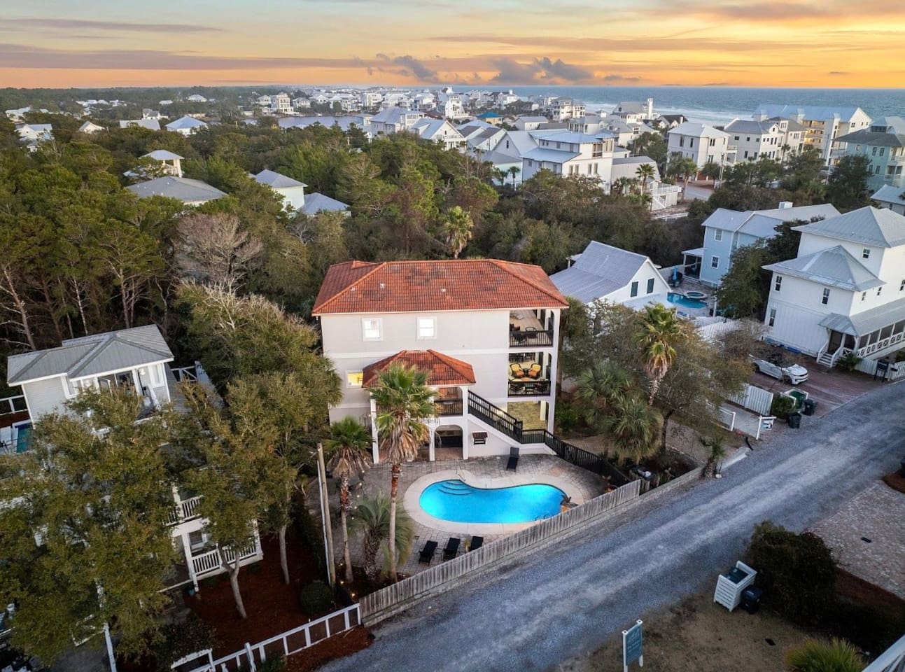 Bird's-eye perspective of your 30A vacation home highlighting the private backyard pool, ample paver parking, and coastal surroundings