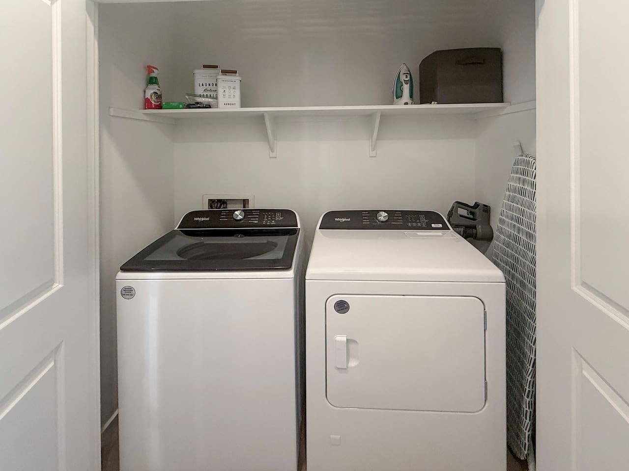 Laundry closet with washer, dryer, shelf, and supplies