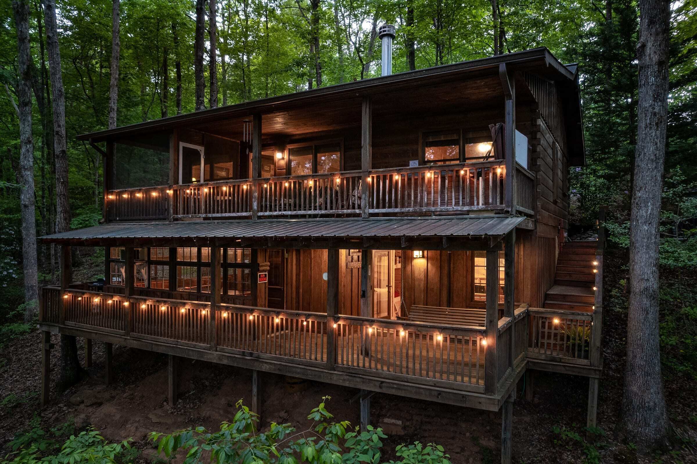 The back of the cabin has two levels for viewing the nature surrounding the cabin. Includes a screened in area for sitting and dining, chairs and a hot tub.
