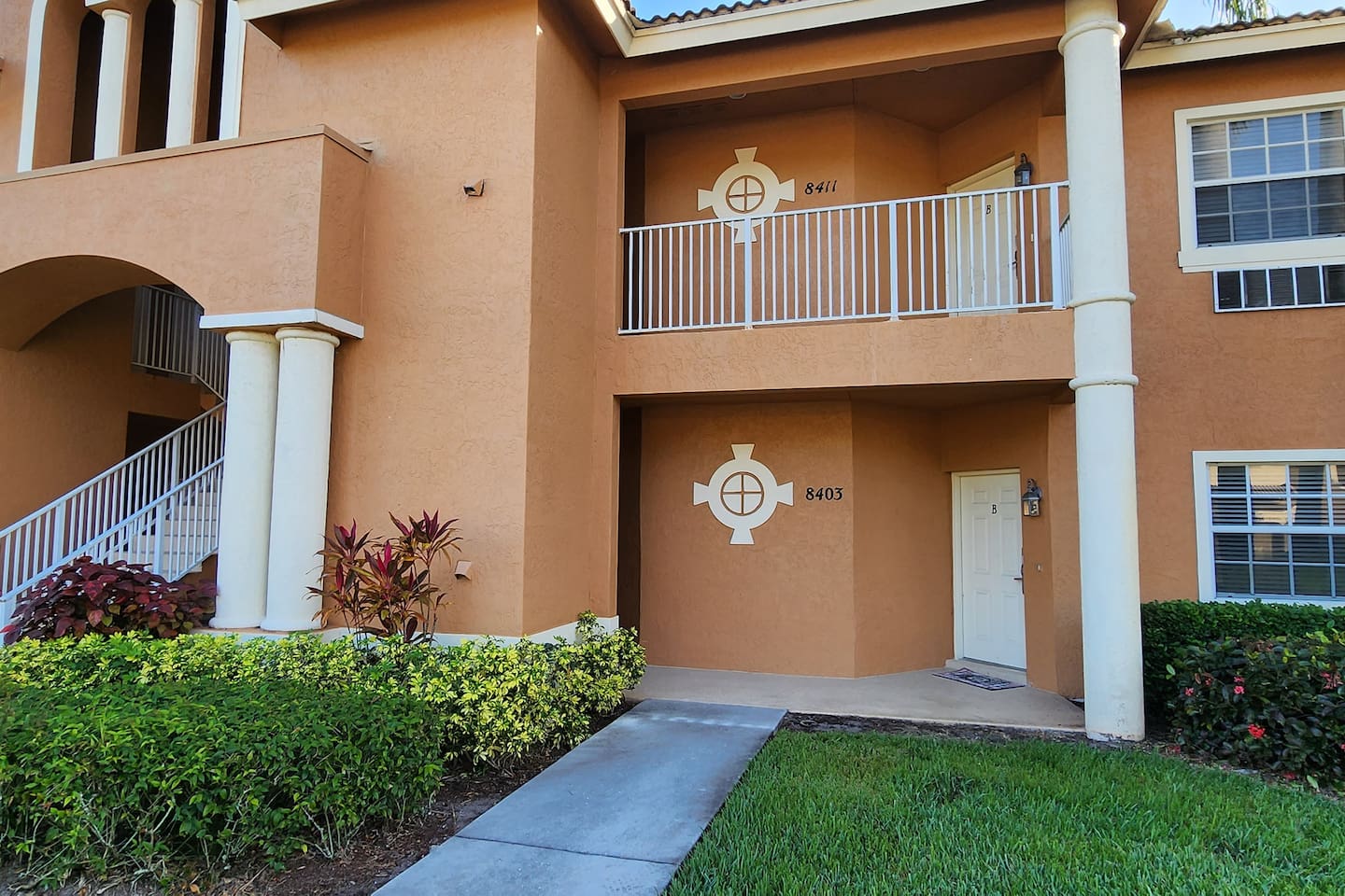 Exterior view of the building with tropical landscaping, covered entryway, and Florida-style architecture.