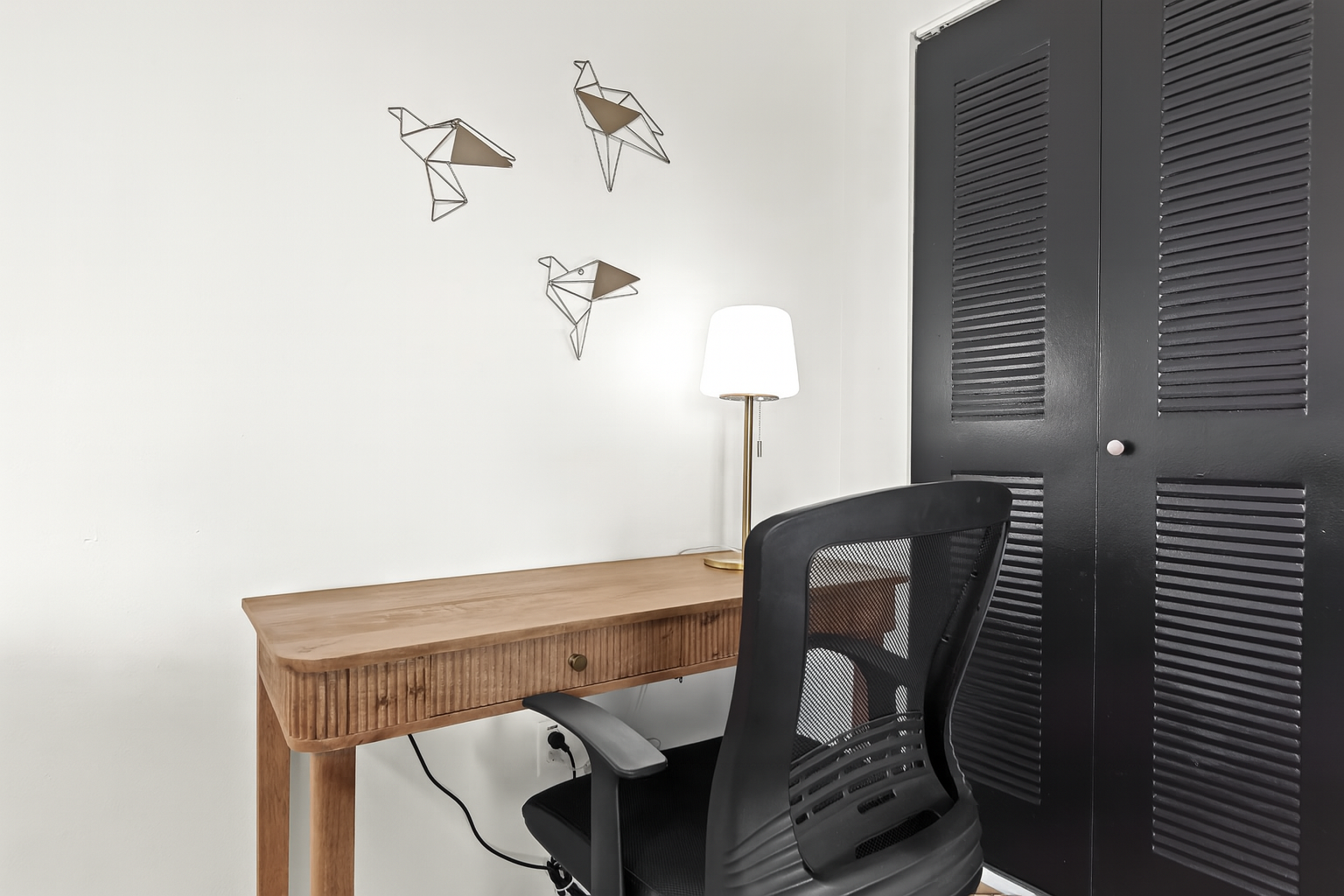 Thoughtfully designed workspace with wall-mounted lighting and a sleek writing desk for remote work or study.