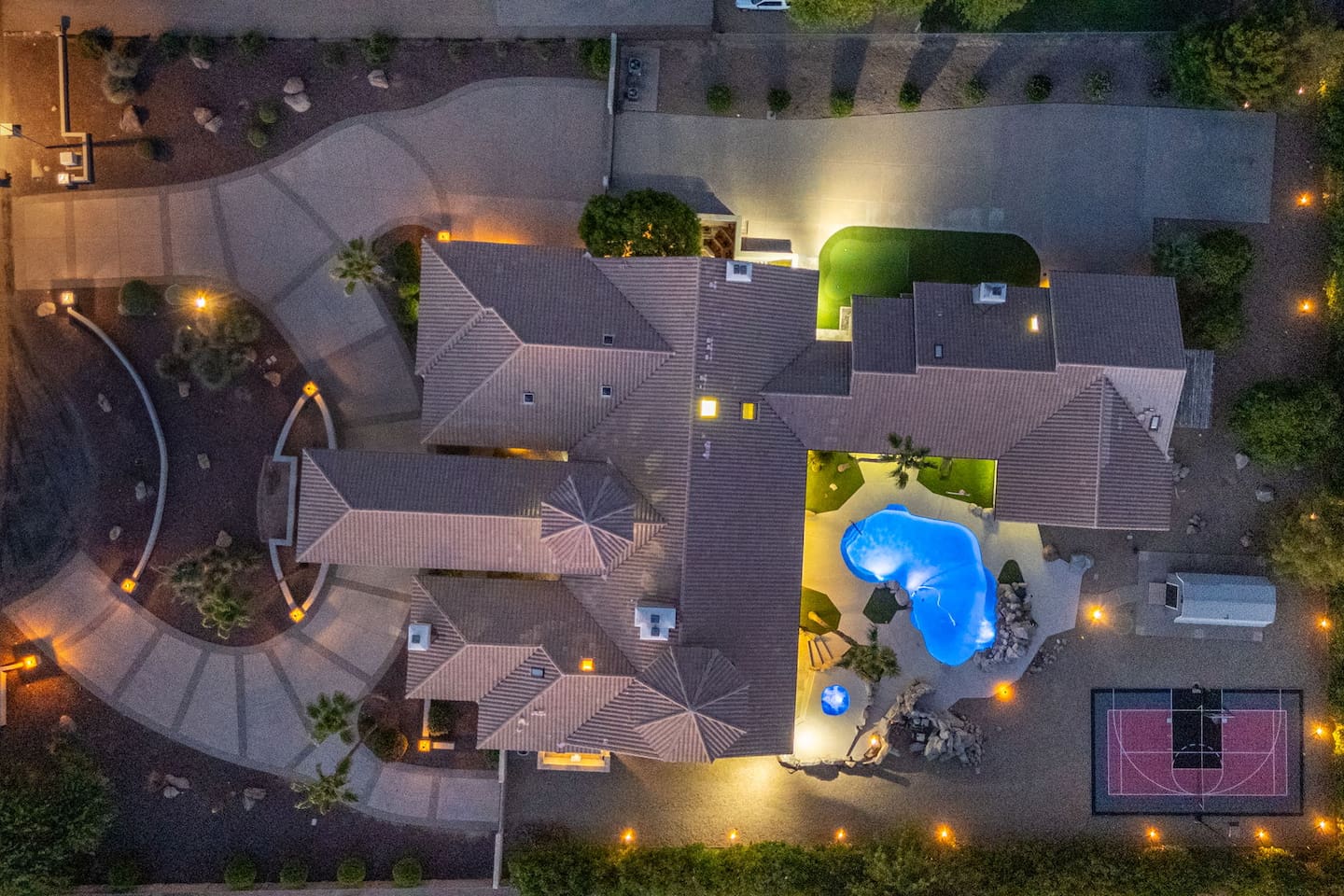 Highlighting the nighttime charm, this aerial view shows your backyard paradise ready for evening entertainment.